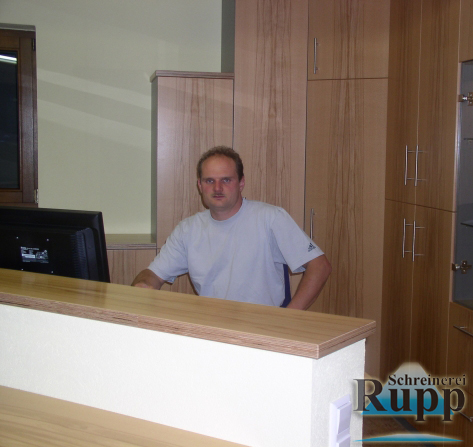 Markus Rupp hinter dem von ihm selbst gebauten Bürotresen aus hellem Holz