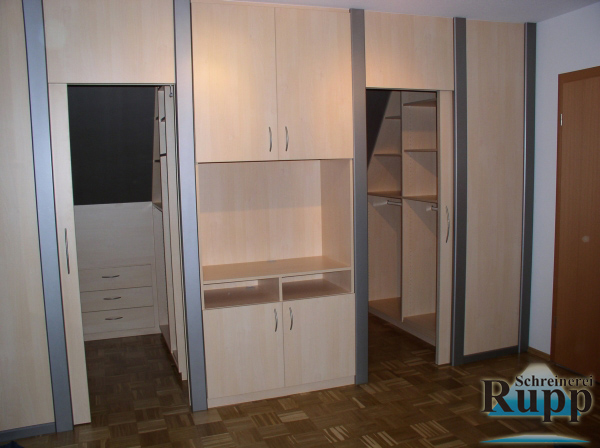 Schlafzimmer-Einbauschrankwand aus hellem Holz mit begehbarem Ankleidebereich