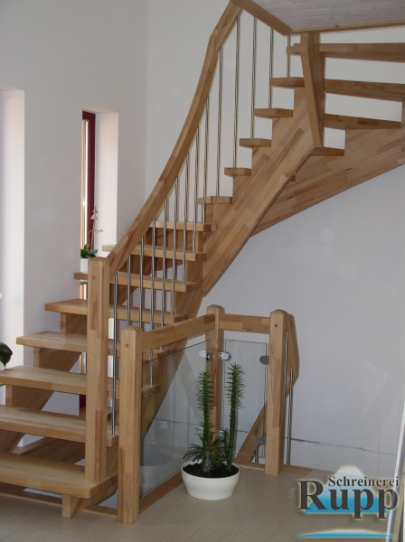 Geschwungene Holztreppe mit Edelstahlstaeben und Glasgelaender in einem Wohnhaus